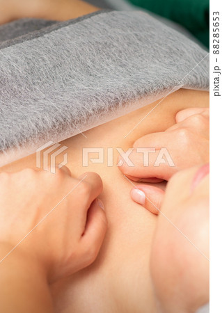 Masseuse with fists makes a chest massage of a young caucasian woman in a spa salon Masseuse with fists makes a chest massage of a young caucasian woman in a spa salon 88285653