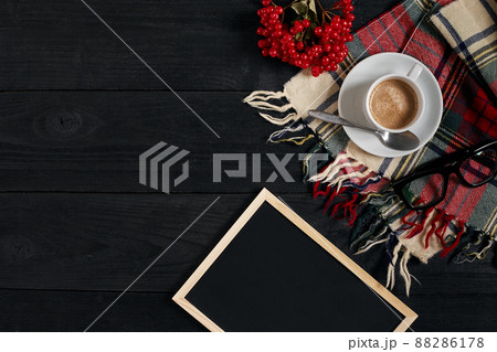 White cup of the coffee and vintage scarf on black wooden background 88286178