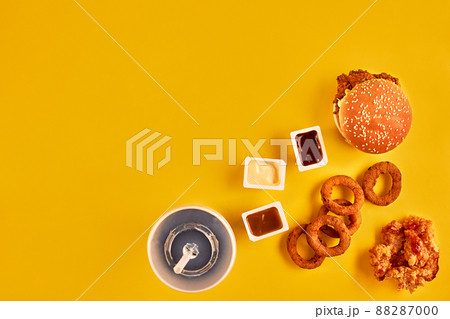 Fast food and unhealthy eating concept - close up of fast food snacks and cold drink on yellow background 88287000