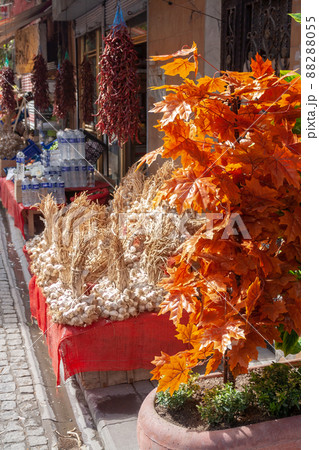 Street stalls with heaps of bunches of garlic and hanging clusters of peppers. 88288055