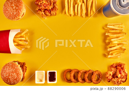 Top view hamburger, french fries and fried chicken on yellow background. Copy space for your text. 88290006