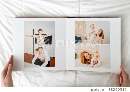 a hands with a Photobook of family at home on a white background. 88290512