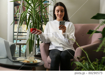 Young blogger with coffee and mobile phone in cafe 88290573