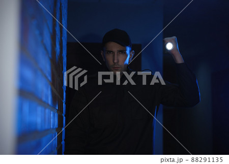 Male security guard with flashlight in dark corridor 88291135