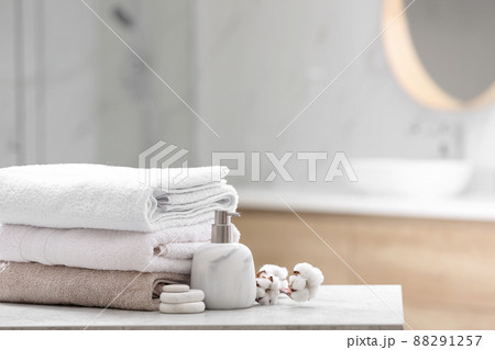 Clean towels, spa stones and soap dispenser on table in bathroom. Space for text Clean towels, spa stones and soap dispenser on table in bathroom. Space for text 88291257