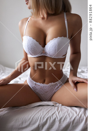 Young woman on her bed wearing white underwear. 88291864