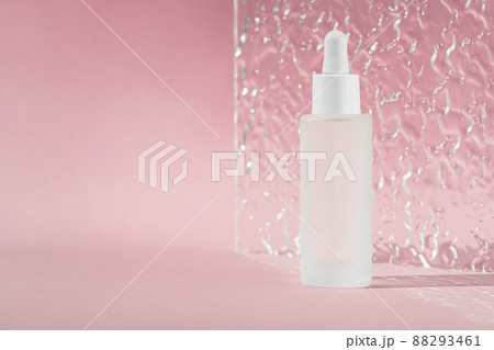 Transparent liquid product in glass bottle. Anti aging serum with collagen and peptides on pink surface with acrylic ribbed sheet. Hyaluronic acid oil mockup. Beauty product mock up. 88293461