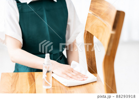 椅子を消毒するエプロンをした女性の手元【パーツカット】 椅子を消毒するエプロンをした女性の手元【パーツカット】 88293918