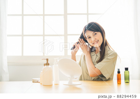 鏡を見るミドル世代の女性（ブラシ・笑顔） 88294459