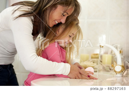 Its so important to wash your hands.... Shot of a mother teaching her daughter how to wash her hands. 88297163