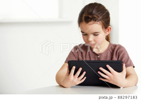 Digital age for all ages. Shot of an adorable little girl reading a digital tablet. 88297183