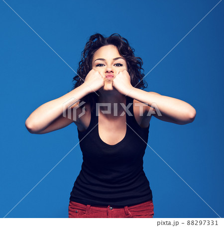 Frustration. Studio portrait of a young woman pressing her fists against her face. 88297331