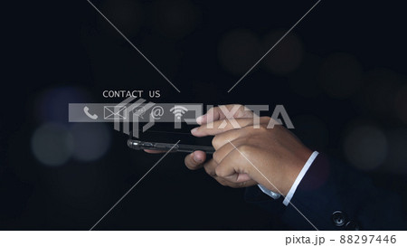Businessman hand using smartphone with icon phone, chat message icon, mail, and address. Businessman hand using smartphone with icon phone, chat message icon, mail, and address. 88297446