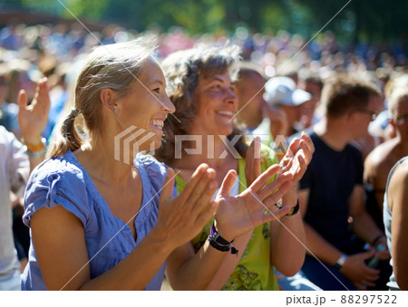 Enjoying the festival vibe. Two mature woman sitting outdoors at a music festival. Enjoying the festival vibe. Two mature woman sitting outdoors at a music festival. 88297522