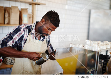 Coffee express. Cropped shot of a handsome male barista using an espresso machine in a cafe. 88298704