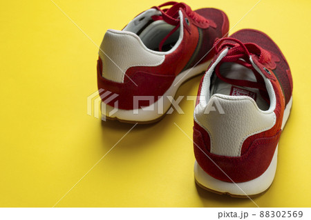 New unbranded running sneaker or trainer on yellow background. Men's sport footwear. 88302569