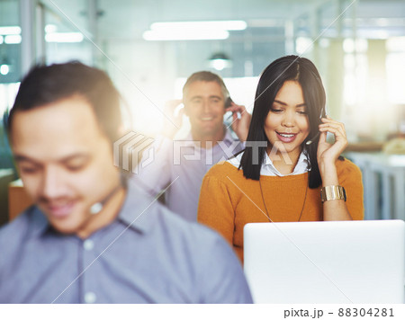 Helping her clients with a smile. Cropped shot of people working in their office. 88304281