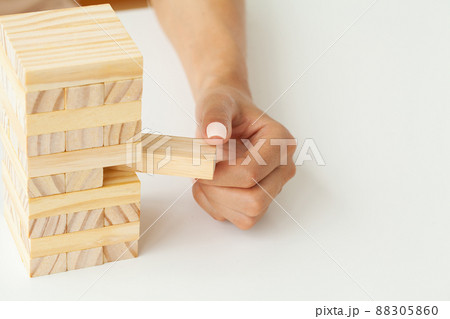 Woman's hand makes wooden cubes on a white table 88305860
