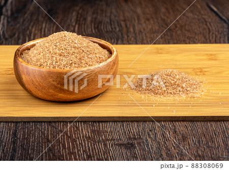 Cane sugar in a bowl and on a cutting board. Cane sugar in a bowl and on a cutting board. 88308069
