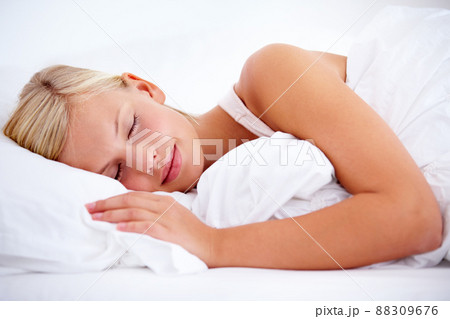 Off to slumberland.... Young woman sleeping comfortably on white linen. Off to slumberland.... Young woman sleeping comfortably on white linen. 88309676
