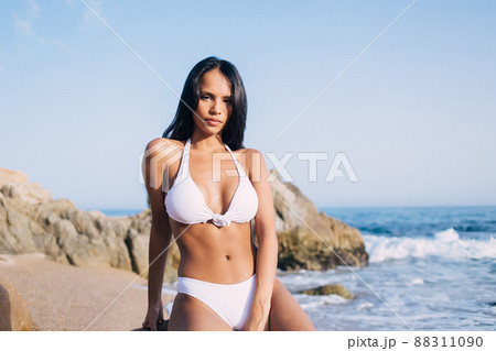 Latin woman with perfect slim figure looking at camera while sunbathing on vacations 88311090
