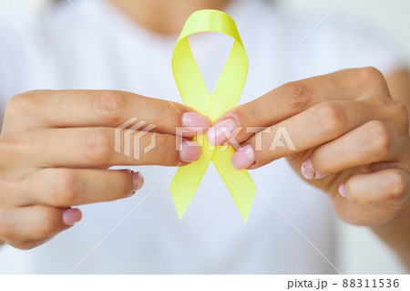Yellow ribbon in hands, symbol Bladder cancer 88311536