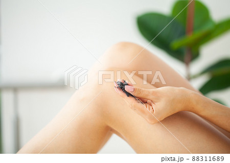 Woman cleans skin of the body with coffee scrub in bathroom. 88311689