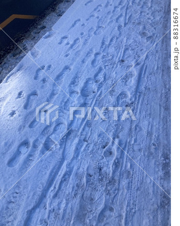 道に降り積もった雪に残る、人の足跡です。 88316674