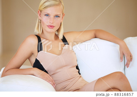 Living the high life. Beautiful young blonde woman sitting on a white couch. 88316857