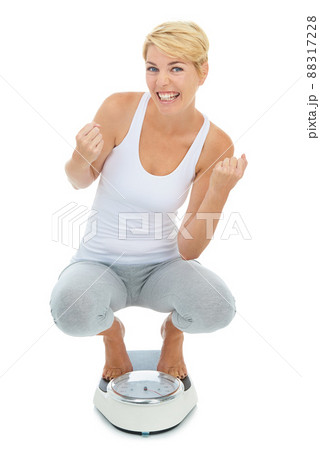 Yes Ive reached my target weight. A young blond woman standing on a scale with her arms raised in celebration. Yes Ive reached my target weight. A young blond woman standing on a scale with her arms raised in celebration. 88317228