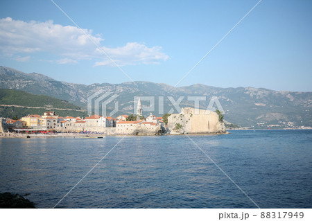 View of old town Budva on mountains background, Montenegro. The resort city located in Budva Riviera of Adriatic Sea for poster, branding, calendar, multicolor card, banner, cover, post, website. A View of old town Budva on mountains background, Montenegro. The resort city located in Budva Riviera of Adriatic Sea for poster, branding, calendar, multicolor card, banner, cover, post, website. A 88317949