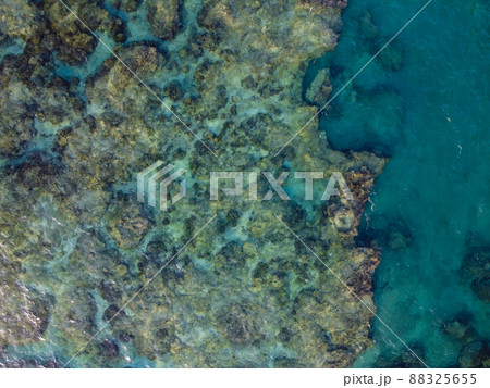 晴れた日の沖縄県島尻郡八重瀬町の透き通る海の干潮時の干潟の空からの写真 88325655