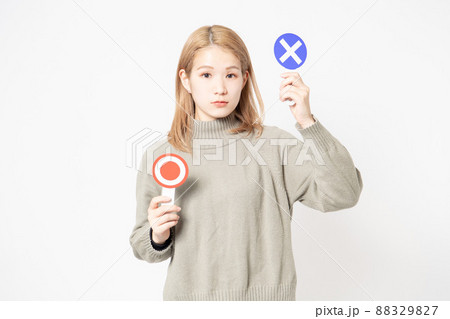白い背景の前に立ってOKとNGのプラカードを見せている若い女性 白い背景の前に立ってOKとNGのプラカードを見せている若い女性 88329827