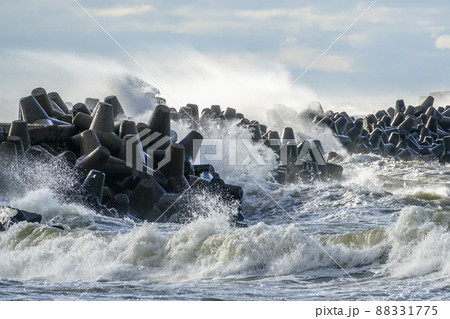 coastal storm in the baltic sea, big waves crash against the harbor breakwater 88331775