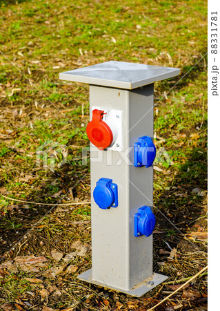 new modern multiple electrical outlets on a low metal pole in a city park 88331781