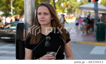 Young pretty woman has a cold drink in the sun of Miami Beach Young pretty woman has a cold drink in the sun of Miami Beach 88334013