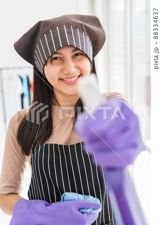Smiling Asian young woman hold spray bottle and cleaning fabric 88334637