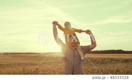 happy family sunset. cheerful father carries little kid daughter his shoulders rays sun. dream childhood. dad kid child play park. happy family concept. joyful baby kid girl fun laughing father sun. 88335528