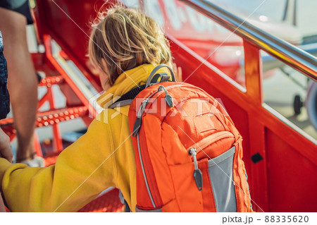 Little boy traveler boarding on the plane Little boy traveler boarding on the plane 88335620