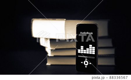Audiobook education. Smartphone screen with audiobook application on paper books black background. Ebook e learning electronic internet mobility concept. Audiobook education. Smartphone screen with audiobook application on paper books black background. Ebook e learning electronic internet mobility concept. 88336567