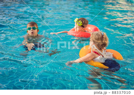 Three little kids playing in the swimming pool Three little kids playing in the swimming pool 88337010
