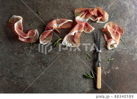Prosciutto with rosemary on an old stone background. 88340589