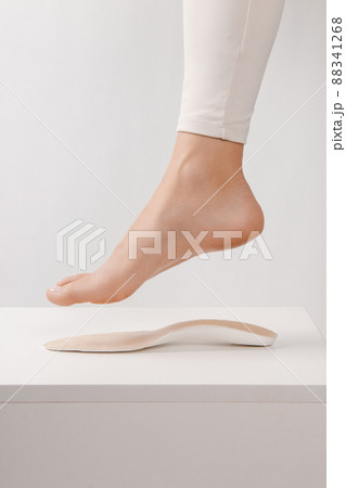 Medical insoles. Isolated orthopedic insoles on a white background. Treatment and prevention of flat feet and foot diseases. Foot care. Insole cutaway layers. Leg hanging over the insole. Medical insoles. Isolated orthopedic insoles on a white background. Treatment and prevention of flat feet and foot diseases. Foot care. Insole cutaway layers. Leg hanging over the insole. 88341268