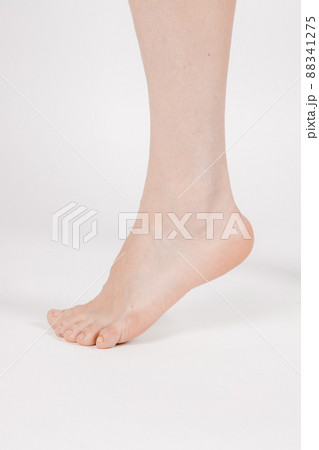 Barefoot and legs isolated on white background. Closeup shot of healthy beautiful female feet. Health and beauty concept. Side view of human foot ream with neutral manicure or pedicure. Sole of foot. 88341275