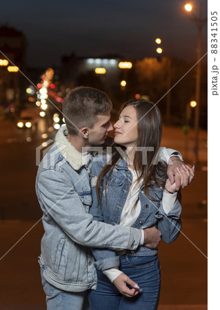 Young beautiful couple hugging on evening city background. Vertical frame 88341505