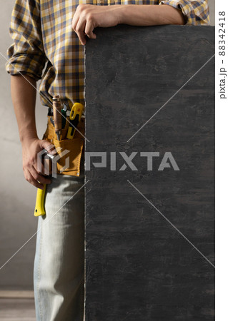 Worker man holding tole at house room renovation. Male hand and black background 88342418