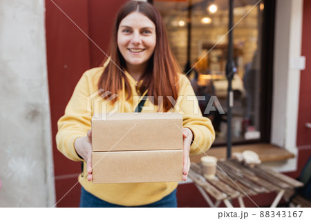 Happy smiling Woman Hands holding two take-out food containers near restaurant. Fast food eco packaging with big breakfast set. Eco recycle environment friendly. Happy smiling Woman Hands holding two take-out food containers near restaurant. Fast food eco packaging with big breakfast set. Eco recycle environment friendly. 88343167
