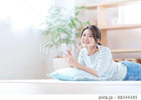 リビングでスマホをする若い女性 88344385