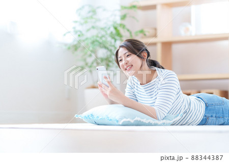 リビングでスマホをする若い女性 リビングでスマホをする若い女性 88344387