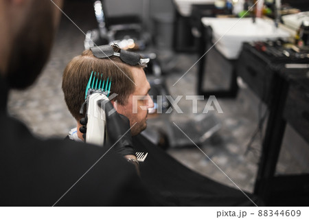 Close up view of b barber master cutting male client with clipper Close up view of b barber master cutting male client with clipper 88344609
